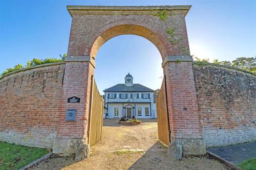 an archway in a brick wall with a building at The Annex at Merley Mews in Poole