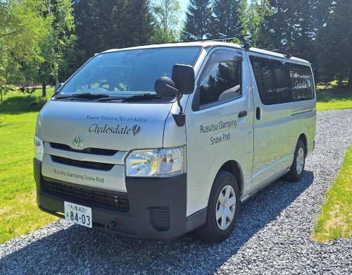 a white van parked on the side of a road at Rusutsu Pension Clydesdale in Rusutsu