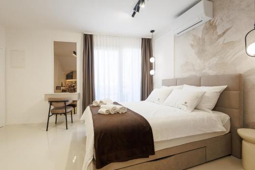 a bedroom with a large bed and a desk at Apartments Maritea in Vodice