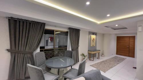 a living room with a table and chairs at 1 BHK Sleek Suite Apt in Bahria Heights 1 in Rawalpindi