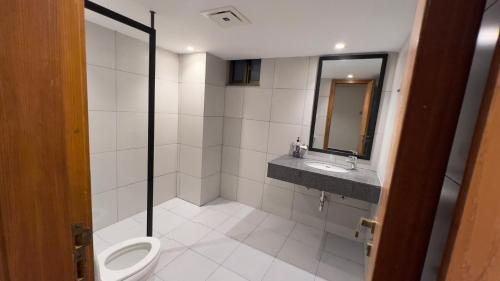 a bathroom with a toilet and a sink and a mirror at 1 BHK Sleek Suite Apt in Bahria Heights 1 in Rawalpindi