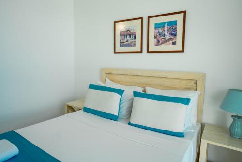 a bedroom with a bed with blue and white pillows at Oceanfront Galle by ICC in Galle