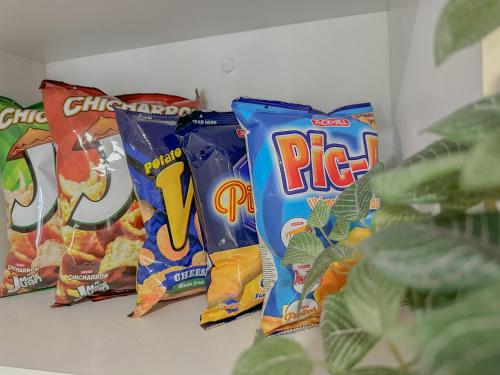 three bags of chips are lined up on a shelf at The Sandscape Suite in Manila