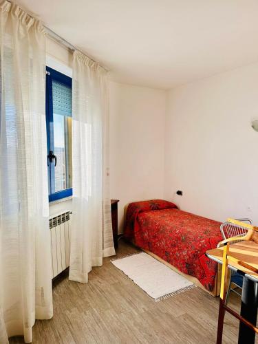 a bedroom with a red bed and a window at Urban Studio Cameri in Cameri