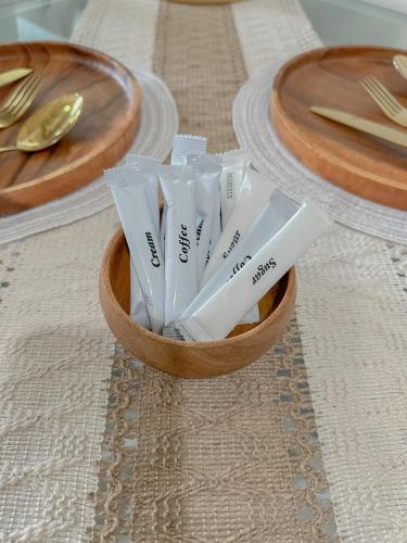 a wooden bowl filled with plastic utensils on a table at The Sandscape Suite in Manila