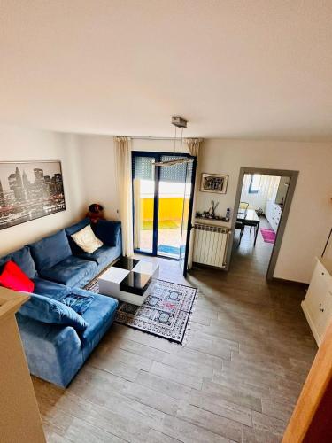 a living room with a blue couch and a table at Urban Studio Cameri in Cameri