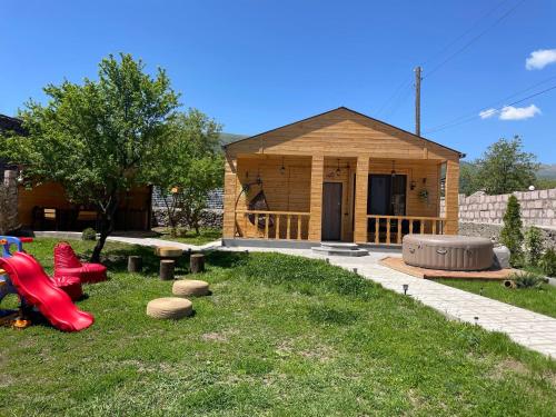 a small wooden house with a playground in the yard at Eco House in Odzun