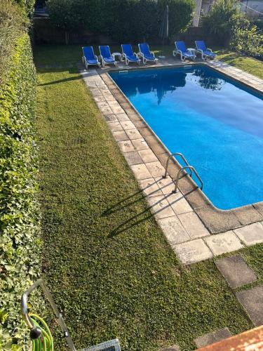 a swimming pool with lounge chairs in a yard at Casa d'Avó Maria - Paraíso no campo - 10pax, com piscina, vistas e vinhas in Marco de Canaveses