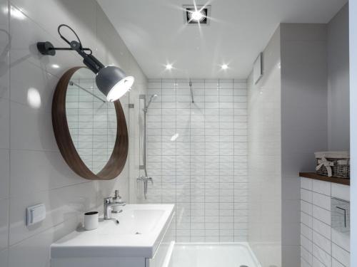 a white bathroom with a sink and a mirror at Apartament z widokiem na dworek in Gdańsk