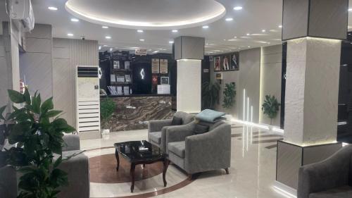 a living room with two chairs and a table at بسمة الفخامة للشقق المخدومة in Abu Arish