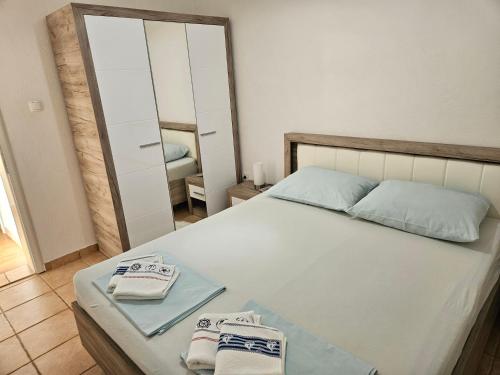 a bedroom with a bed with towels on it at Apartments KraljicaMira in Splitska