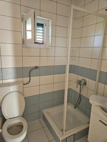 a bathroom with a toilet and a shower at Apartments KraljicaMira in Splitska