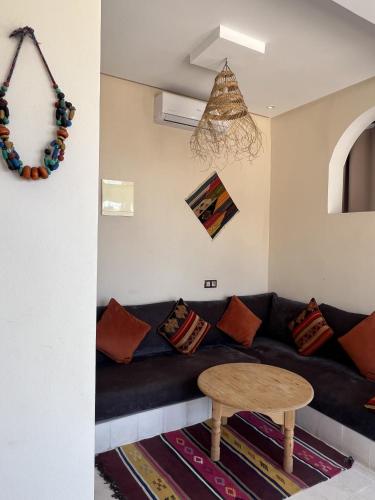 a living room with a couch and a table at SurfAppart Morocco in Tamraght Ouzdar
