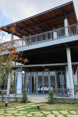 a large building with a balcony on top of it at Lá Đỏ HomeStay Bảo Lộc - Lâm Đồng in Ấp Thiện Lập