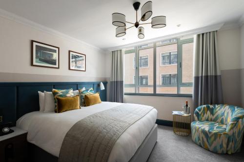 a bedroom with a bed and a chair at The Chamberlain in London