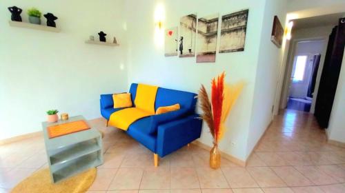 un salon avec un canapé bleu et une table dans l'établissement Trilocale spiaggia 5 minuti a piedi, à Roquebrune-Cap-Martin