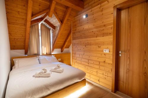 a bedroom with a bed with towels on it at Bujtina Harusha in Theth