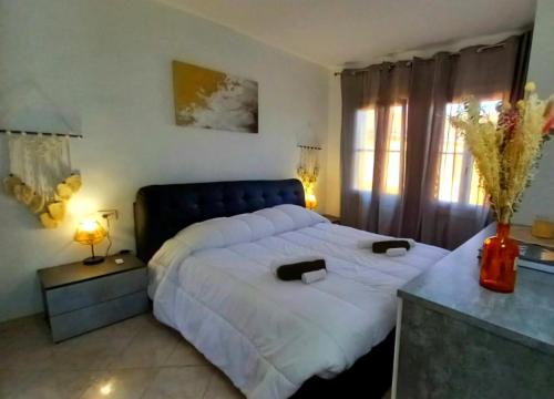 une chambre avec un grand lit avec des draps blancs dans l'établissement Trilocale spiaggia 5 minuti a piedi, à Roquebrune-Cap-Martin