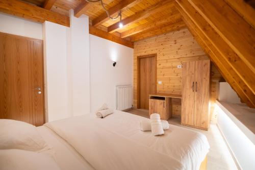 a bedroom with a white bed with towels on it at Bujtina Harusha in Theth