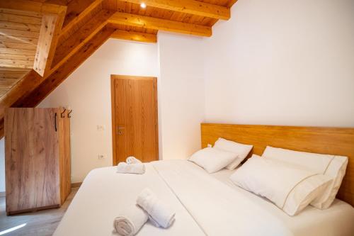 a bedroom with a bed with towels on it at Bujtina Harusha in Theth
