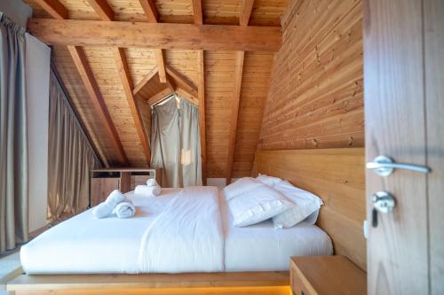 a bedroom with a bed with white sheets and pillows at Bujtina Harusha in Theth