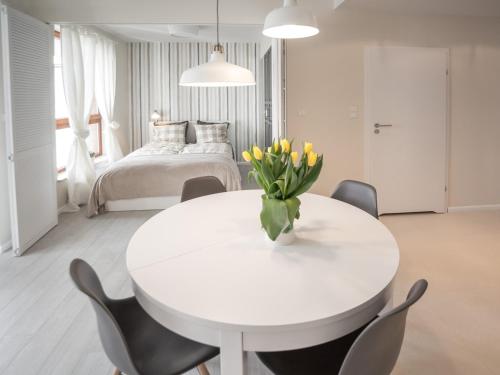 a white dining room with a white table and chairs at Apartament z widokiem na dworek in Gdańsk