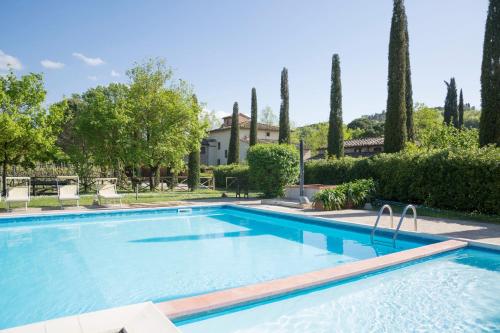 a swimming pool in front of a house with trees at Villa Sestilia Guest House in Montaione