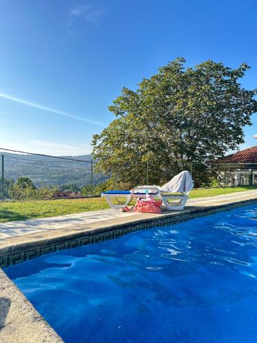 a swimming pool with two chairs sitting next to it at Casa d'Avó Maria - Paraíso no campo - 10pax, com piscina, vistas e vinhas in Marco de Canaveses