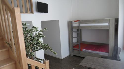a room with two bunk beds and a television at Hôtel de Clèves in Nevers