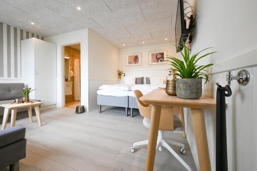 a bedroom with a bed and a table with a plant at Rold Gl Kro in Arden