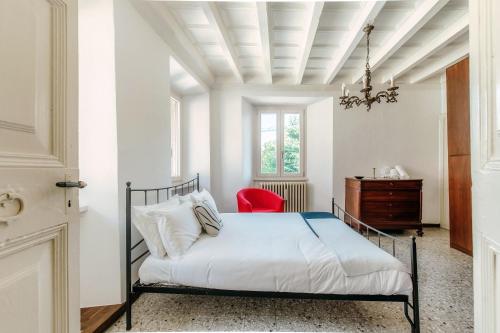 赫拉弗多纳Riflessi sul Lago by Quokka 360 - Historic apartment with lake view的一间卧室，有一张床和一把红椅子