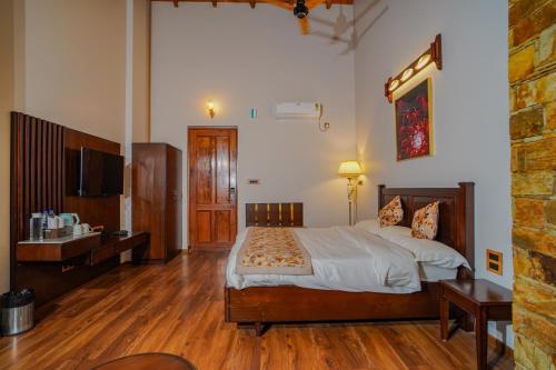 a bedroom with a large bed and a television at Neelesh Inn- A Luxury Lake View Hotel- 20 kms from Nainital in Bhīm Tāl