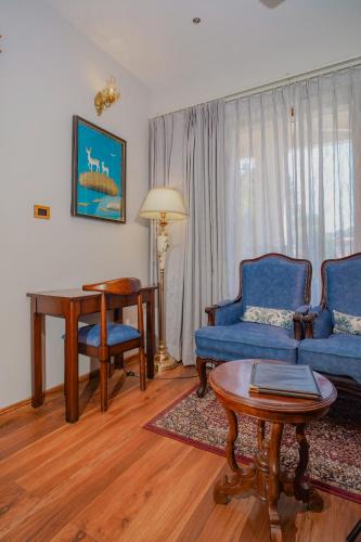 a living room with a blue couch and a table at Neelesh Inn- A Luxury Lake View Hotel- 20 kms from Nainital in Bhīm Tāl