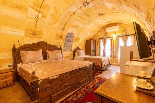 a bedroom with a large bed and a tv in it at Walnut House in Goreme