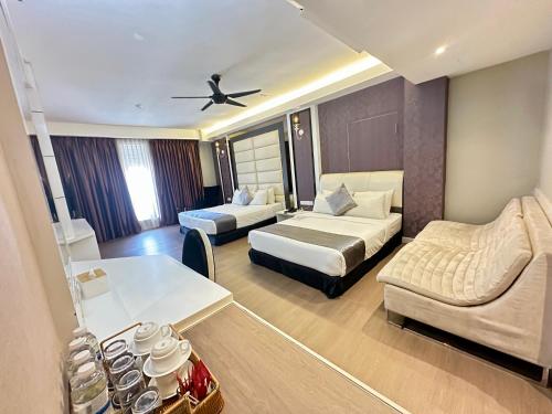 a hotel room with two beds and a couch at The Sterling Boutique Hotel Melaka in Melaka