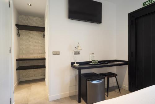 a room with a desk and a tv on a wall at La Playa Suites Suances in Suances