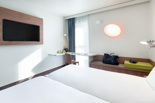 a hotel room with two beds and a flat screen tv at Campanile Clermont Ferrand Centre in Clermont-Ferrand