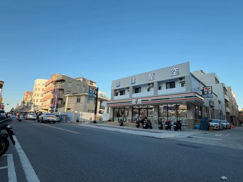 a city street with buildings and motorcycles parked on the street at 海洋星空民宿 in Magong