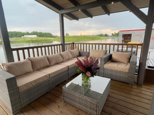 a living room with a couch and a table on a porch at Atpūtas māja "Rūdupji" in Gulbene