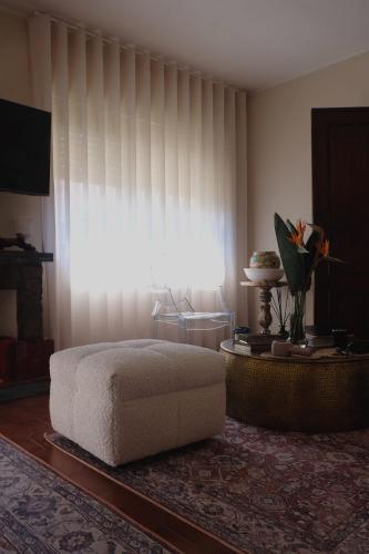 a bedroom with a white bed and a large window at Villa Baltazar in Vila do Conde