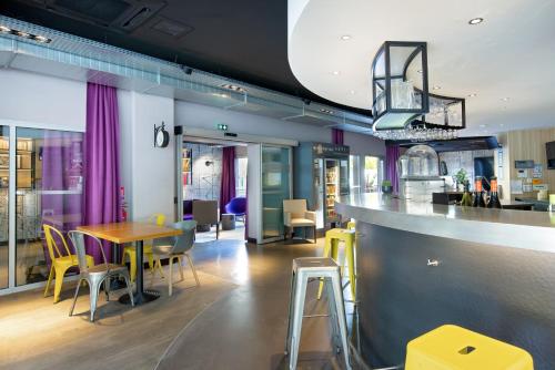 a restaurant with a bar and tables and chairs at Campanile Clermont Ferrand Centre in Clermont-Ferrand