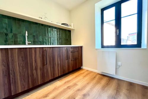 ナンシーにあるNancy Pépinière Appartement rénové et équipéのシンクと窓のあるキッチン
