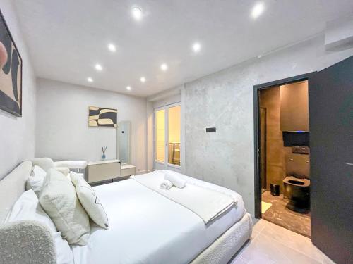 - une chambre blanche avec un grand lit et un canapé dans l'établissement 11 - Studio Champs-Elysees, à Paris