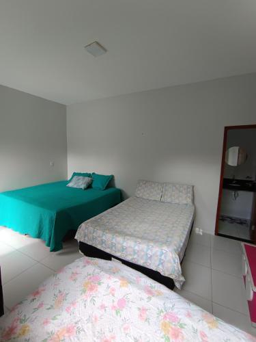a room with two beds and a mirror at Quarto Sol Nascente in Tianguá