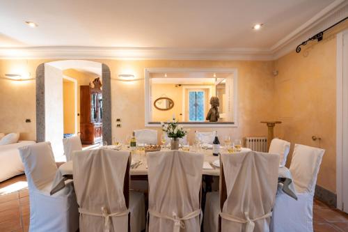 a dining room with a table with white chairs at TENUTA CAVI 6&4, Emma Villas in Colleferro