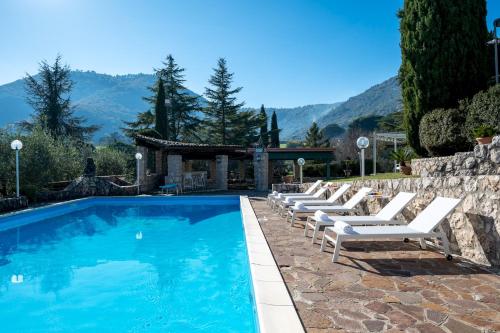 a pool with lounge chairs next to a stone wall at TENUTA CAVI 6&4, Emma Villas in Colleferro
