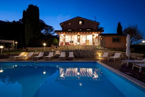 a villa with a swimming pool at night at TENUTA CAVI 6&4, Emma Villas in Colleferro