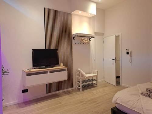 a bedroom with a tv on a dresser and a bed at Boomgaard de Luxe in Antwerp