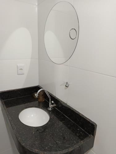 a bathroom with a sink and a mirror at Quarto Sol Nascente in Tianguá