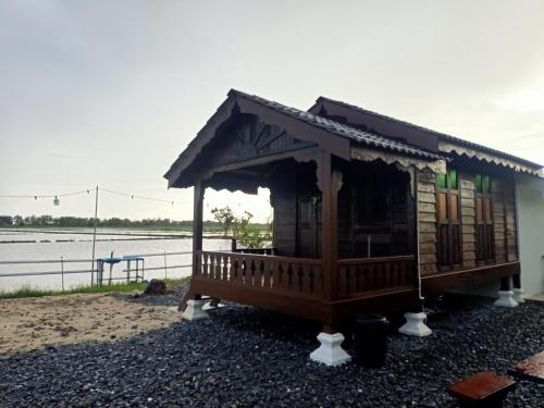 a small house on the shore of a body of water at Chinta Chinta Cottage Chalet Kayu in Arau